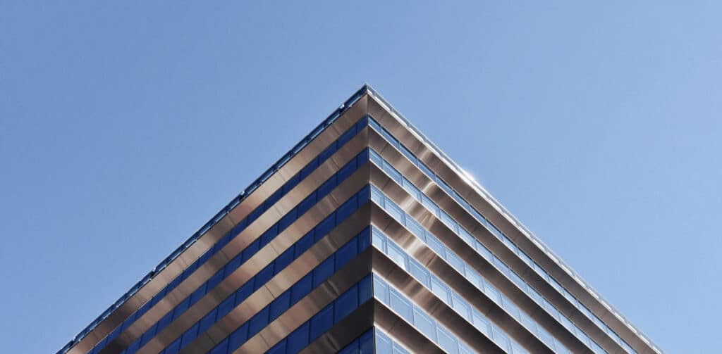 Dramatic angle looking up at a commercial modern building's edge.